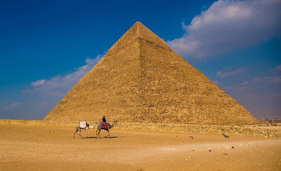 https://travelpast50.com/wp-content/uploads/2023/10/pyramids-camel-1.jpg