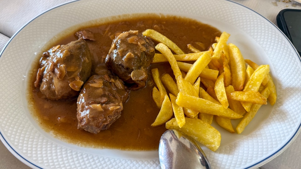 Traditional pork cheeks in almond sauce with fried potatoes at Venta El Albero roadside restaurant near Jerez de la Frontera