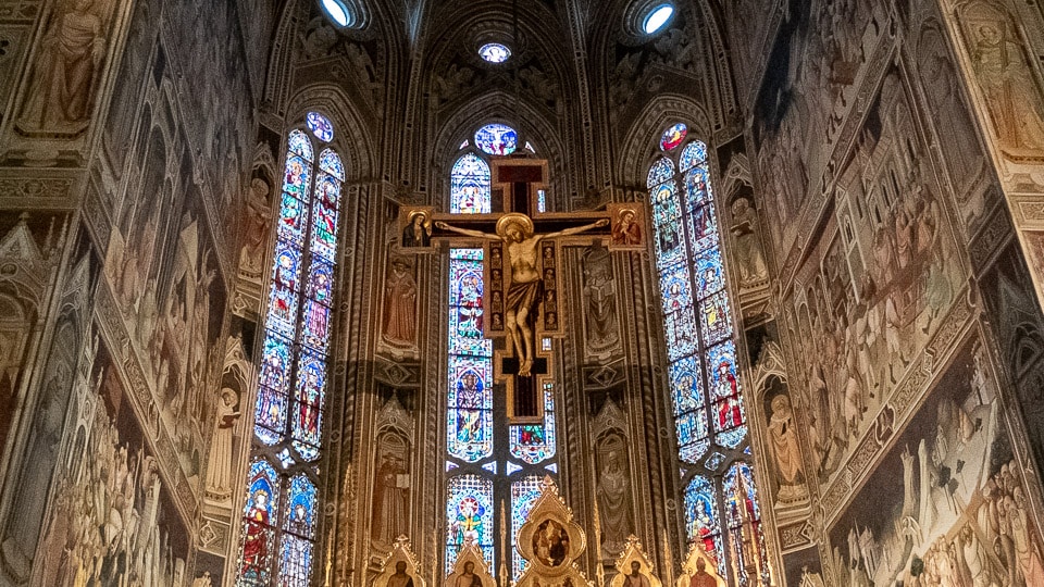 The crucifix flanked by the stunning stained glass windows of the Basilica of Santa Croce in Florence.