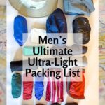 Tom's complete men's ultralight travel packing list laid out flat on a map — Tilley hat, Kuhl pants, merino t-shirts, rolled socks, toiletry bags, and travel accessories — all fitting in one 35-liter carry-on backpack for travelers over 50.
