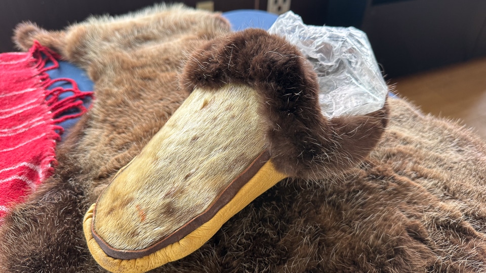 Tlingit clan member Herb presenting a traditional moccasin during an onboard cultural talk