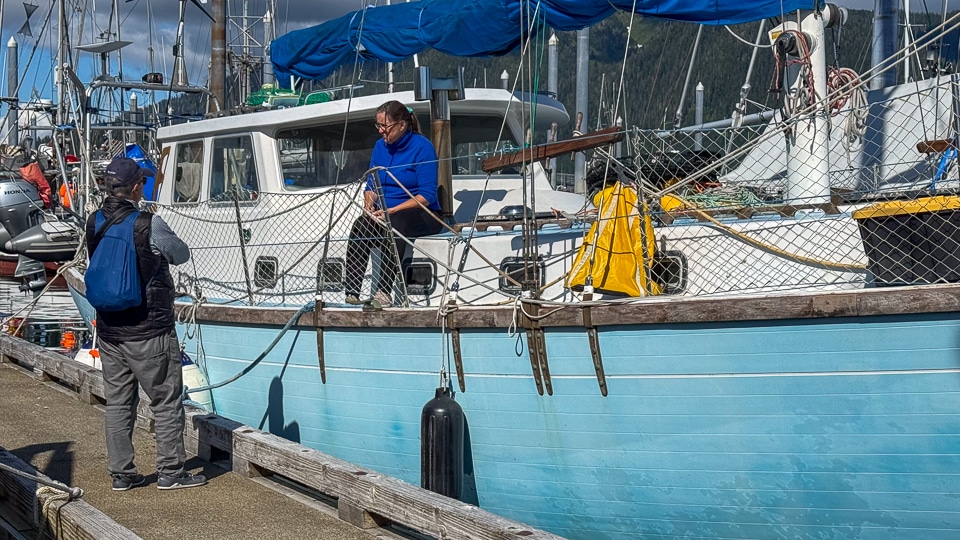 Local fisherman talking with visitors at the harbor in Petersburg, Alaska