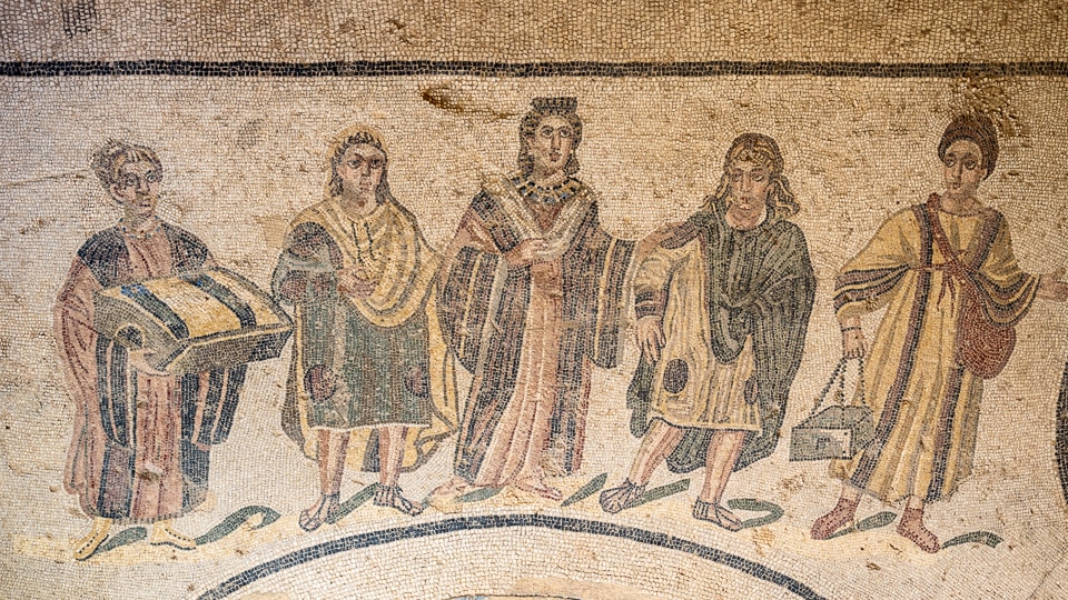 Mosaic of a richly dressed Roman woman flanked by two children and two servants carrying a clothes bundle and a box of bath supplies