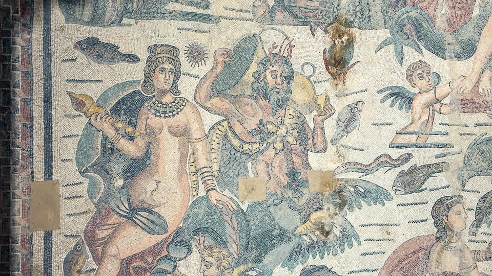 Bearded triton with crab-claw horns beside a sea nymph holding a conch shell, with a winged cupid and fish, Arion room mosaic